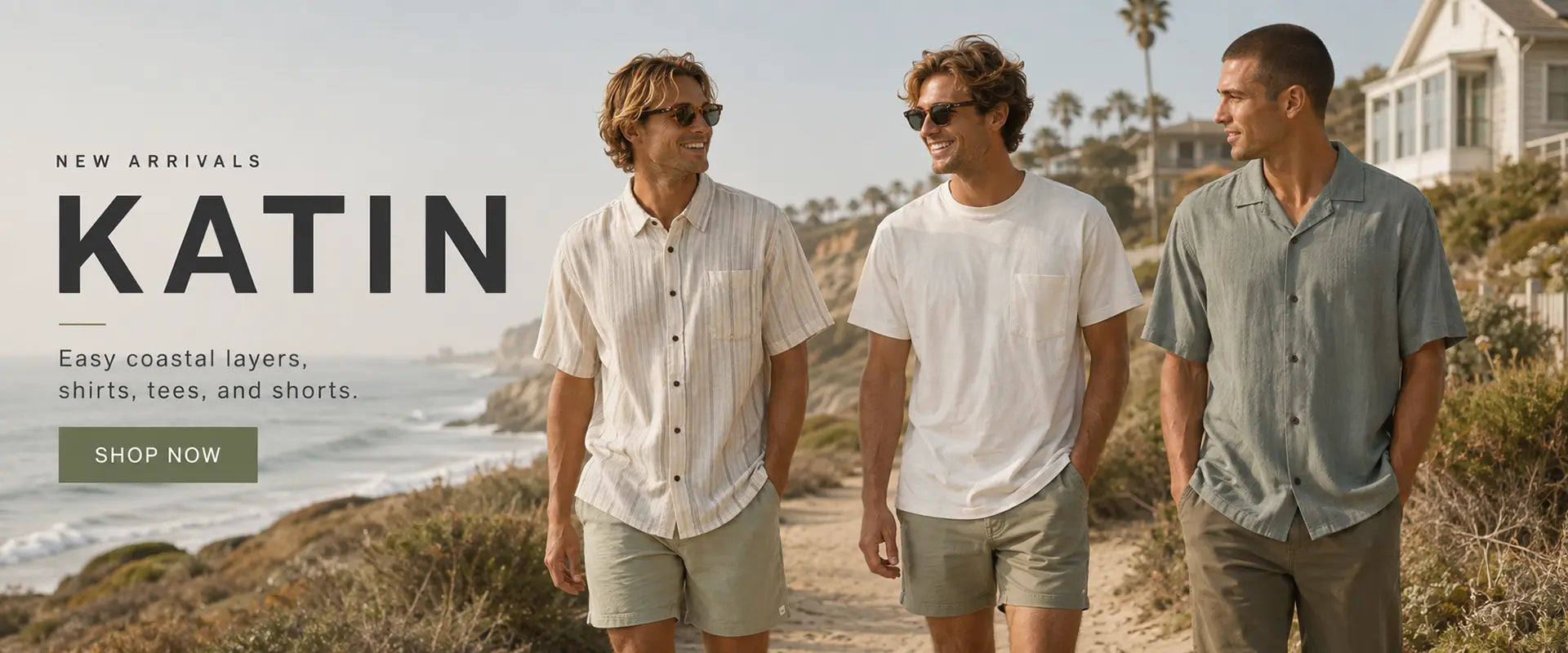 Three men walking outdoors on a coastal path wearing casual layered apparel from Katin, with large 'KATIN' text and a 'SHOP NOW' button on the left side of the image.